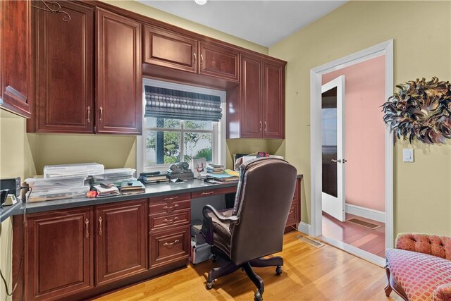 office space featuring light hardwood / wood-style flooring and built in desk