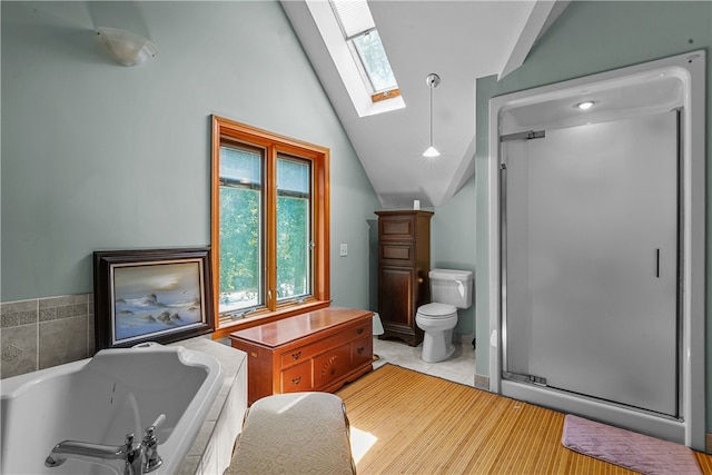 bathroom featuring toilet, shower with separate bathtub, and lofted ceiling with skylight