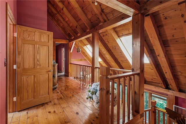 hallway featuring beam ceiling, high vaulted ceiling, light hardwood / wood-style floors, and wooden ceiling