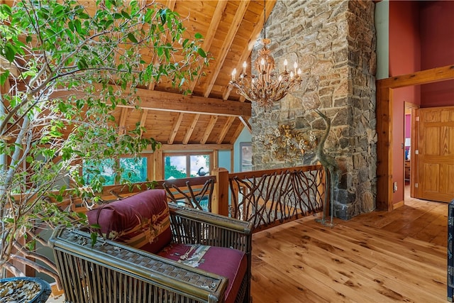 stairway featuring hardwood / wood-style flooring, beamed ceiling, wooden ceiling, high vaulted ceiling, and an inviting chandelier