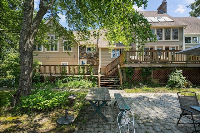 rear view of property featuring a patio and a deck