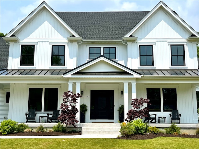 modern farmhouse with a front lawn and covered porch