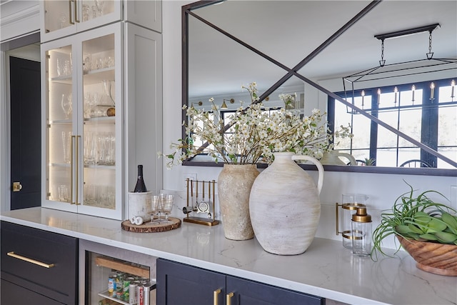 bar featuring beverage cooler and light stone countertops