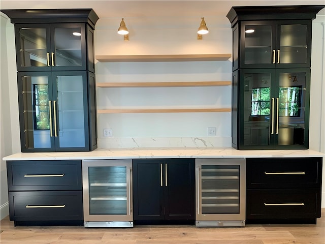 bar with light hardwood / wood-style flooring, refrigerator, and beverage cooler