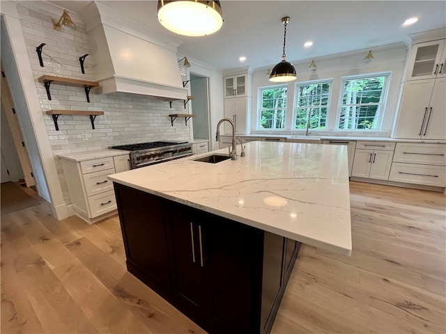 kitchen featuring light hardwood / wood-style floors, white cabinets, backsplash, and double oven range