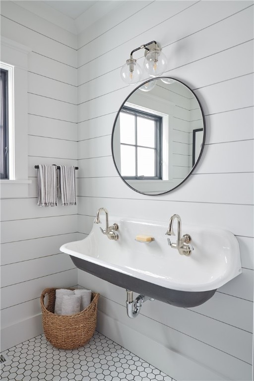 bathroom with sink, wood walls, and tile patterned floors