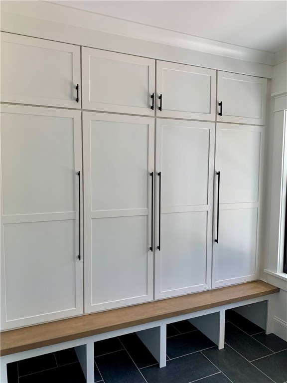 mudroom featuring dark tile patterned flooring