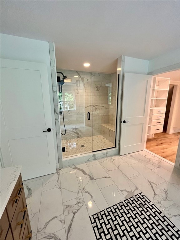 bathroom with a shower with shower door, vanity, and hardwood / wood-style flooring