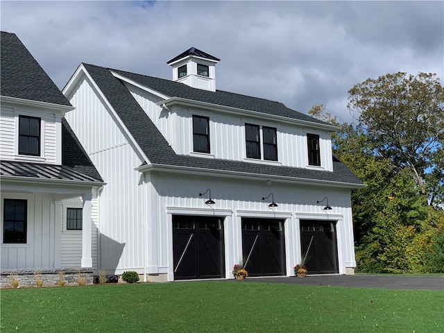 modern farmhouse featuring a garage and a front yard