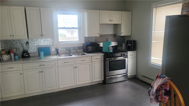 kitchen with a baseboard radiator, gas range, white cabinets, fridge, and sink