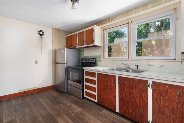 kitchen with appliances with stainless steel finishes, backsplash, dark hardwood / wood-style floors, and sink