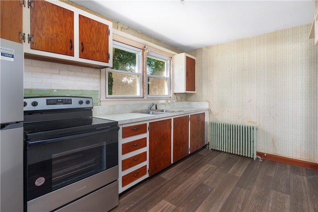 kitchen featuring radiator heating unit, dark hardwood / wood-style floors, stainless steel appliances, and sink