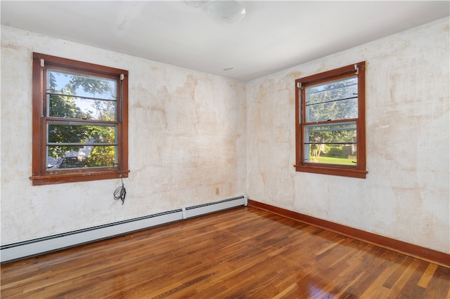 spare room with baseboard heating and wood-type flooring