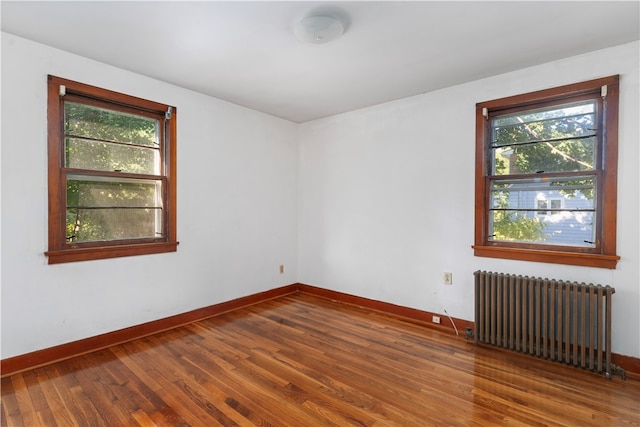 spare room featuring hardwood / wood-style floors and radiator heating unit