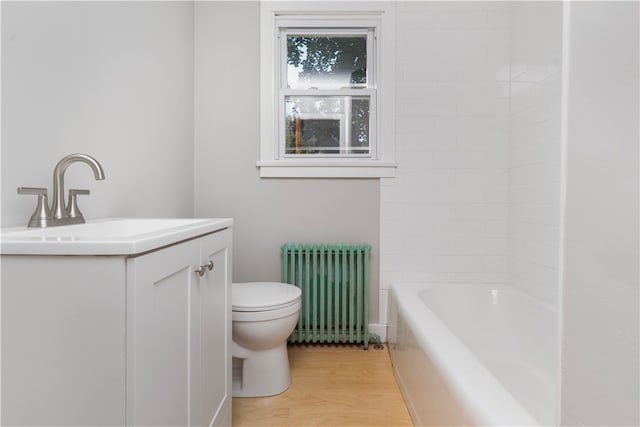 full bathroom with radiator, toilet,  shower combination, vanity, and hardwood / wood-style floors