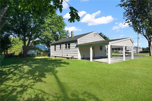 rear view of house featuring a patio area and a lawn