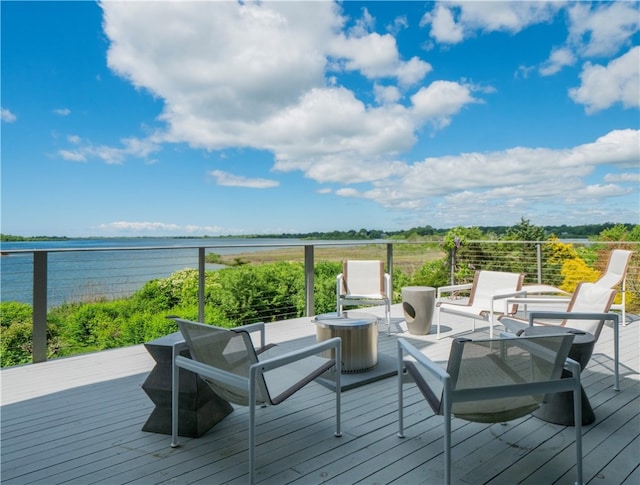 wooden deck with a water view and outdoor lounge area