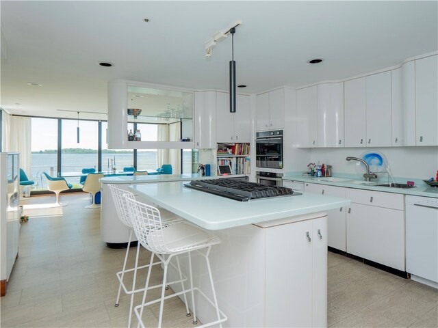 kitchen with light tile patterned floors, a kitchen island, dishwasher, and white cabinetry