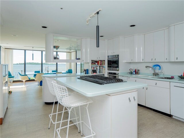150 Southern Way, Charlestown, RI 02813 - kitchen featuring appliances with stainless steel finishes, a center island, light countertops, a sink, and white cabinetry