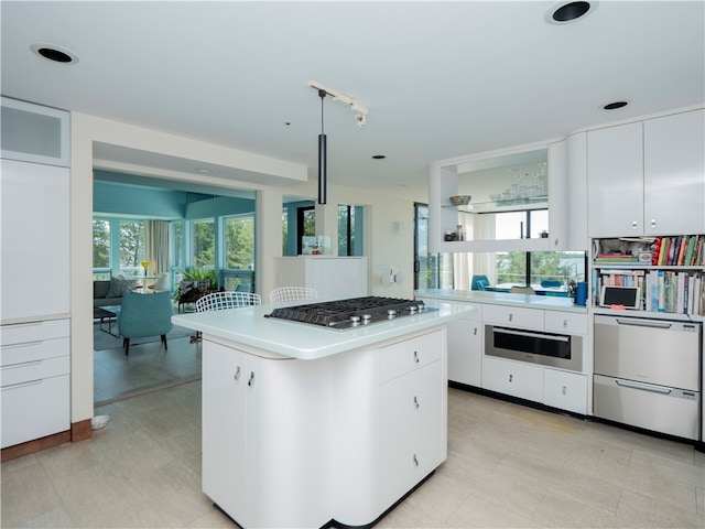 kitchen featuring light tile patterned floors, appliances with stainless steel finishes, a center island, and white cabinetry