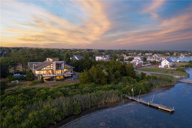 aerial view at dusk featuring a water view