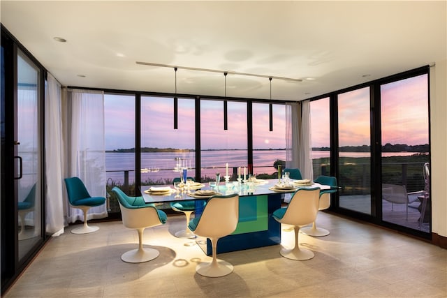 sunroom featuring a water view