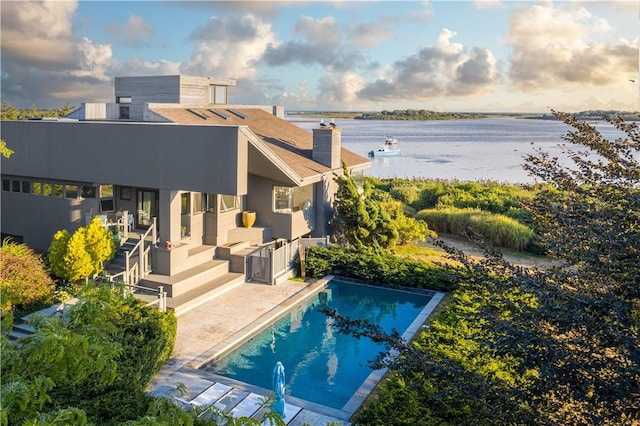 150 Southern Way, Charlestown, RI 02813 - rear view of house with a water view, a chimney, a patio, and an outdoor pool
