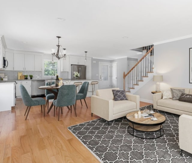 living room featuring hardwood / wood-style floors, crown molding, and an inviting chandelier