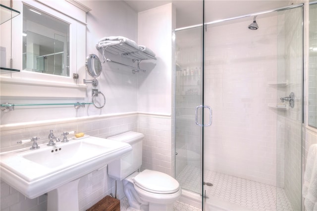 bathroom featuring toilet, walk in shower, and tile walls