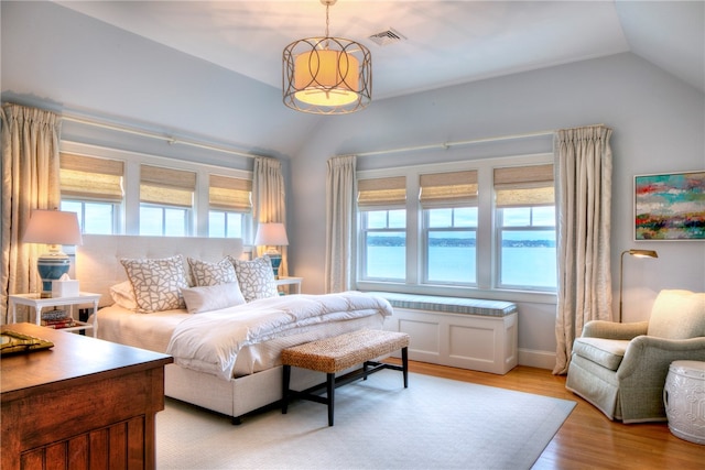 bedroom featuring light hardwood / wood-style flooring and lofted ceiling