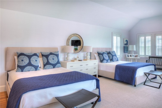 bedroom with vaulted ceiling and light wood-type flooring