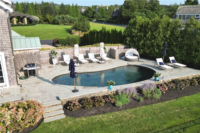 view of pool featuring a patio area, area for grilling, and a lawn