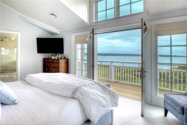 bedroom featuring multiple windows, ensuite bathroom, carpet, and lofted ceiling