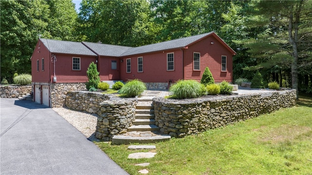 ranch-style home featuring a front lawn and a garage