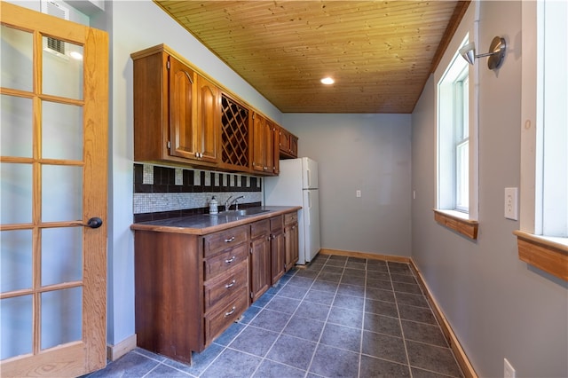 kitchen featuring sink, dark tile patterned flooring, tasteful backsplash, wood ceiling, and lofted ceiling