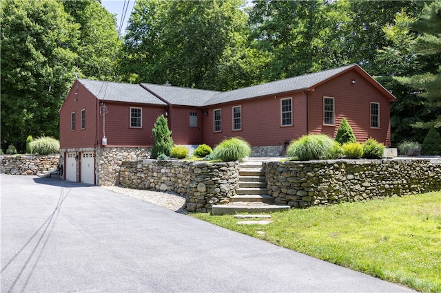 ranch-style home featuring a front yard and a garage