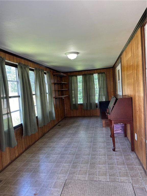 miscellaneous room with tile patterned flooring and wood walls