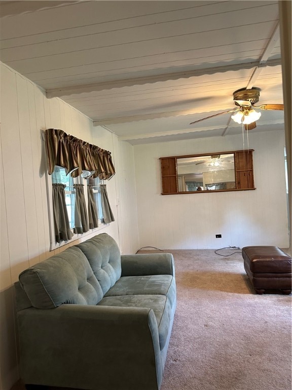 carpeted living room featuring ceiling fan and beamed ceiling