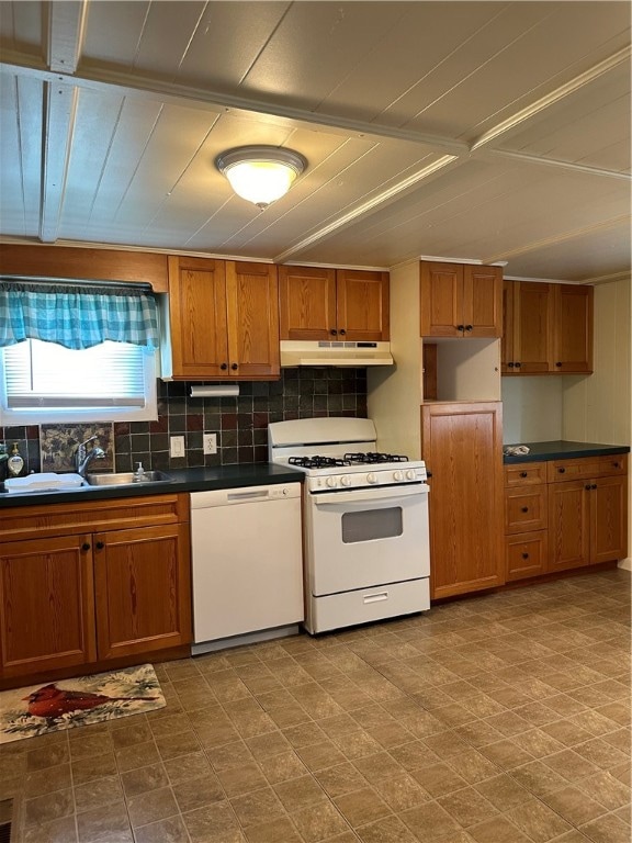 kitchen with sink, tasteful backsplash, tile patterned flooring, and white appliances