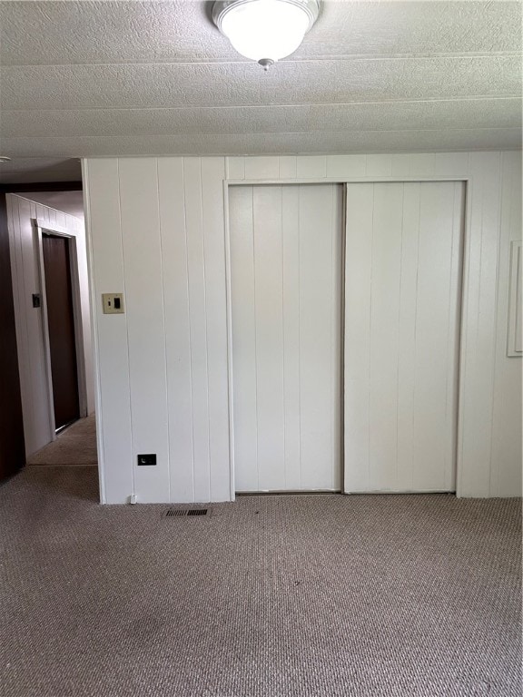 unfurnished bedroom with a closet and light colored carpet