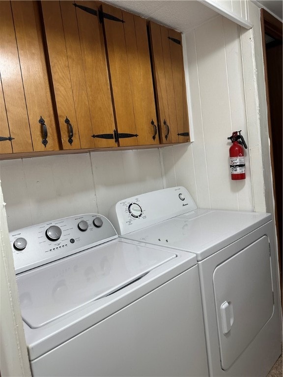 laundry room featuring cabinets and washer and clothes dryer