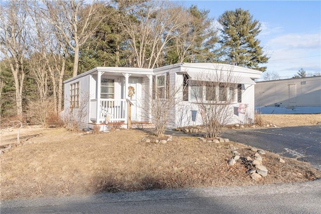 manufactured / mobile home featuring covered porch and aphalt driveway