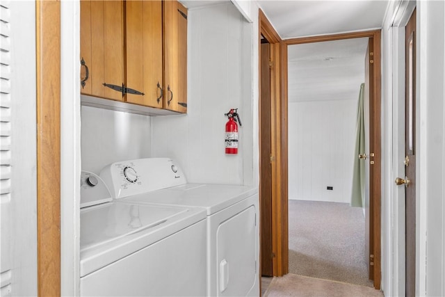 laundry room featuring cabinet space, independent washer and dryer, and light colored carpet