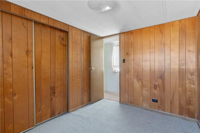 carpeted empty room with wooden walls