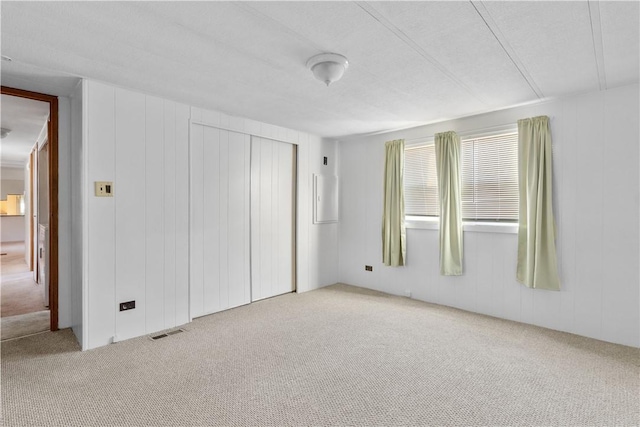 unfurnished bedroom featuring a closet, carpet, and visible vents