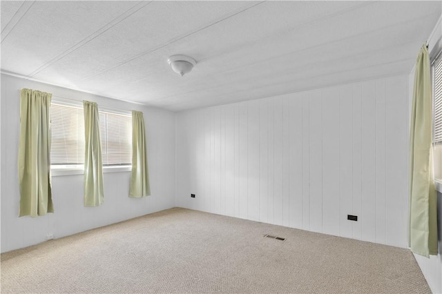 carpeted empty room featuring visible vents