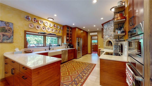 kitchen featuring kitchen peninsula, appliances with stainless steel finishes, light hardwood / wood-style floors, and sink