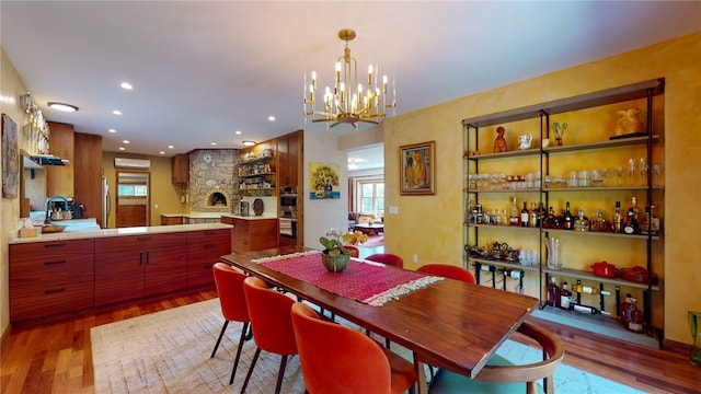 dining area featuring light wood-type flooring, sink, and a chandelier