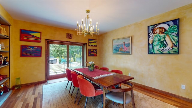 dining area featuring wood-type flooring and a chandelier