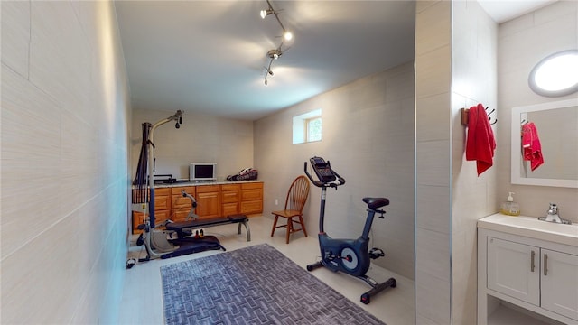 exercise room with sink and rail lighting